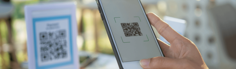Pessoa com celular fazendo pagamento online com QR Code. 